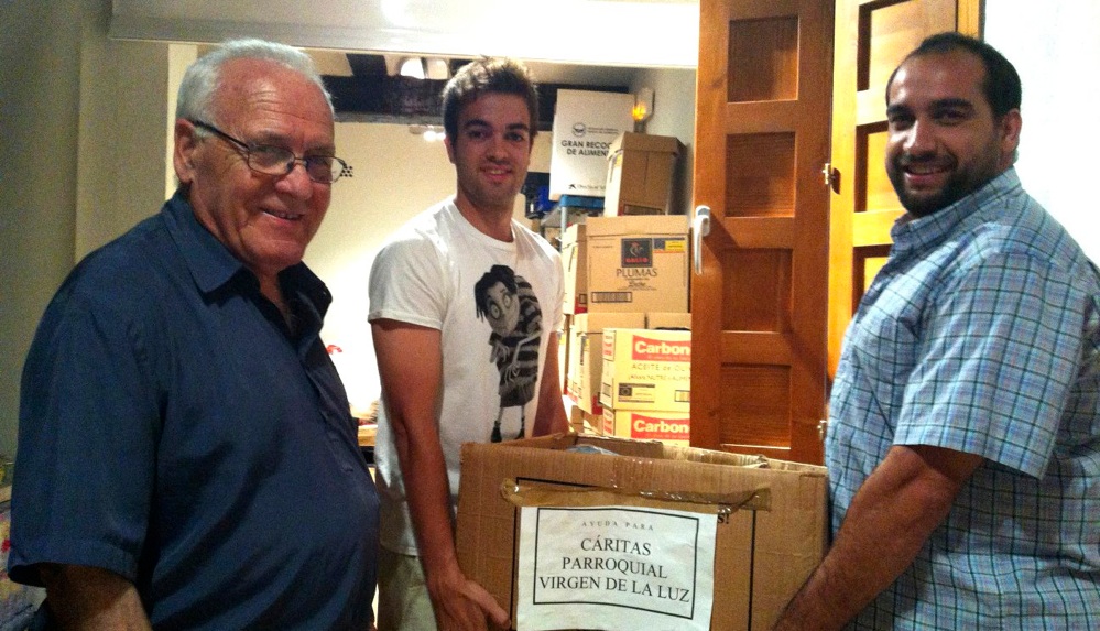 Los capitanes entregando la comida recogida para el banco de alimentos de la parroquia a D. Ángel.